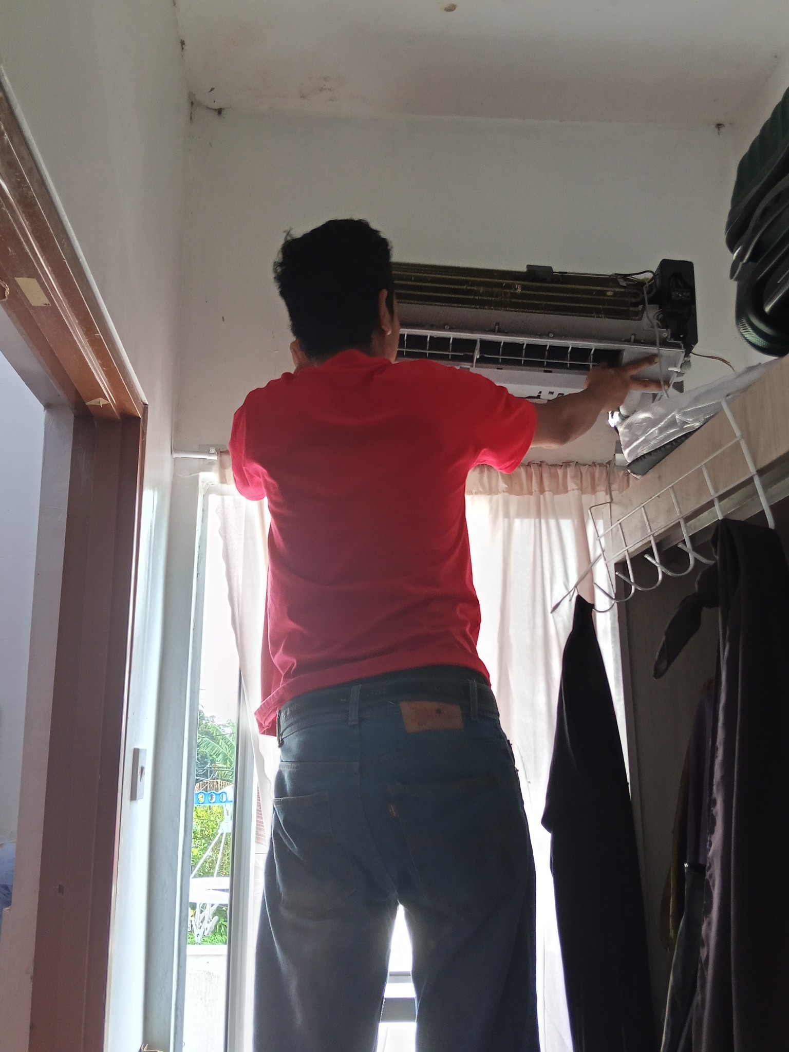 Juruteknik FZ Aircond sedang membaiki penyaman udara